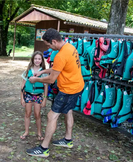 Sécurisation d'une enfant avec un gilet de sauvetage pour une descente en canoë